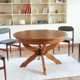 Table ronde vintage à rallonge en chêne massif éditée par Lübke, Allemagne années 60, estampille d'origine sous le plateau, piétement central à quatre jambes plates croisées en X réunies par un moyeu rond, allonge centrale