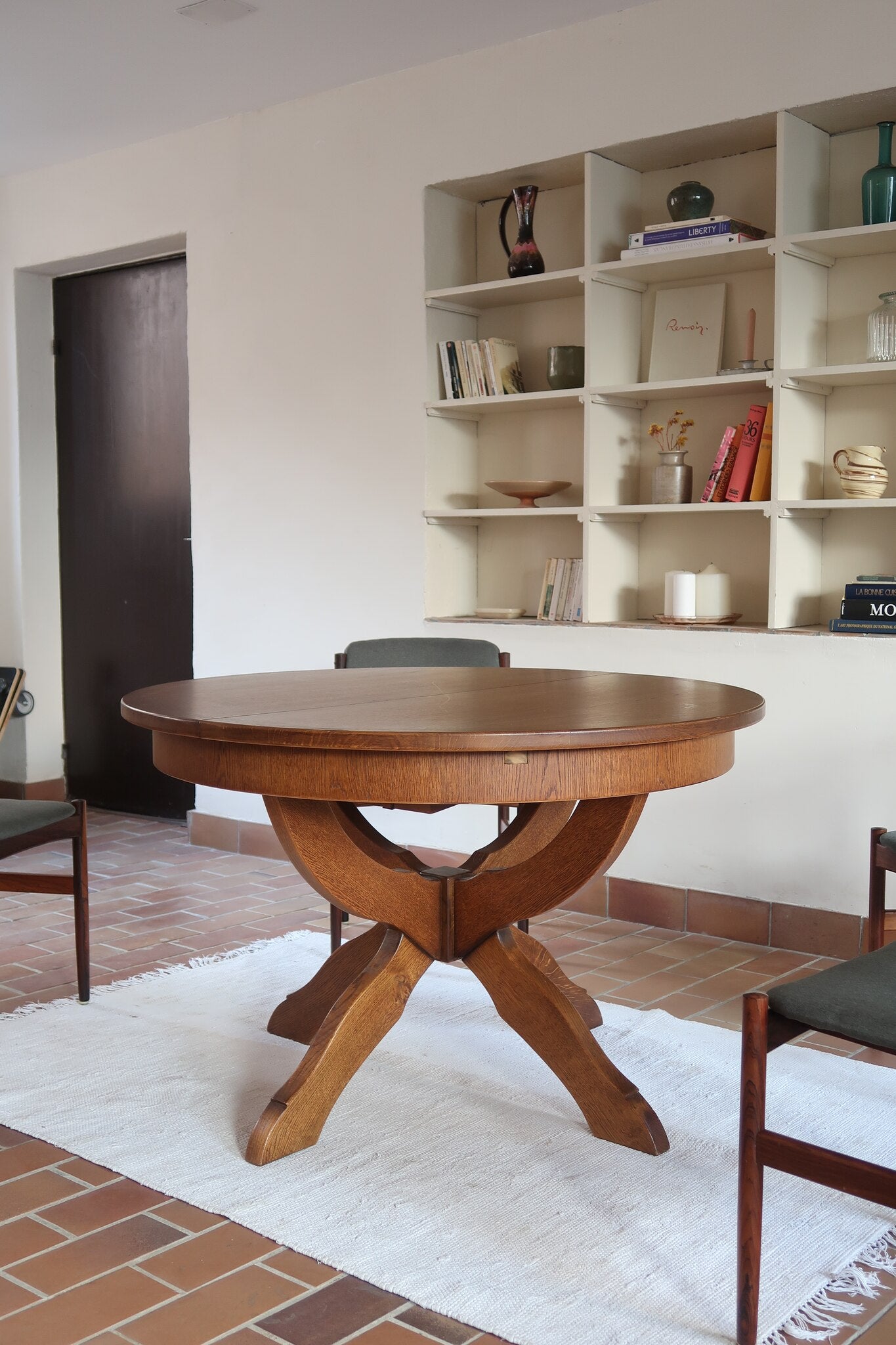 Table ronde vintage à rallonge en chêne massif éditée par Lübke, Allemagne années 60, estampille d'origine sous le plateau, piétement central à quatre jambes plates croisées en X réunies par un moyeu rond, allonge centrale
