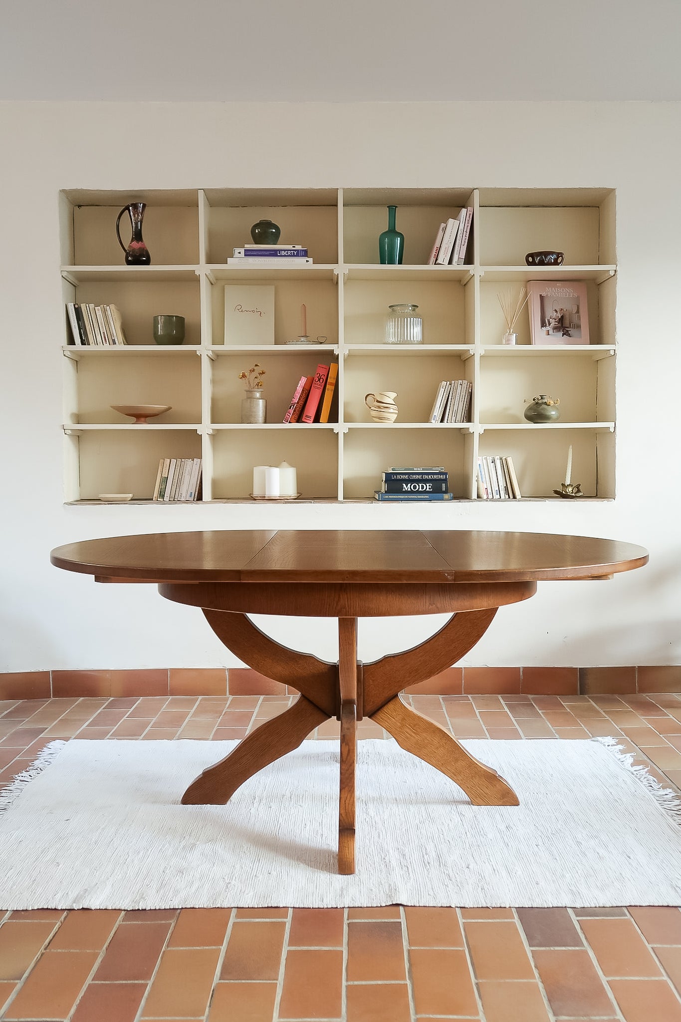 Table ronde vintage à rallonge en chêne massif éditée par Lübke, Allemagne années 60, estampille d'origine sous le plateau, piétement central à quatre jambes plates croisées en X réunies par un moyeu rond, allonge centrale