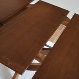 Table ronde vintage à rallonge en chêne massif éditée par Lübke, Allemagne années 60, estampille d'origine sous le plateau, piétement central à quatre jambes plates croisées en X réunies par un moyeu rond, allonge centrale