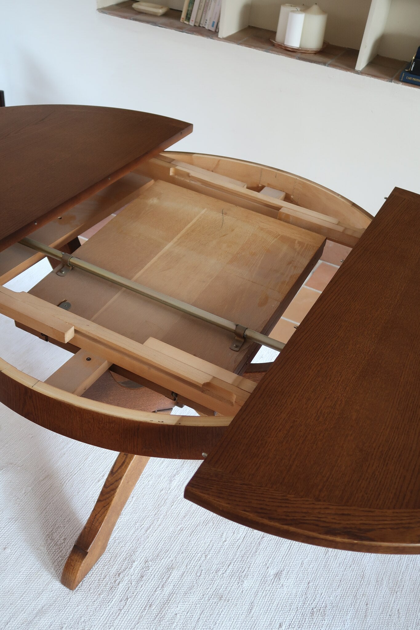 Table ronde vintage à rallonge en chêne massif éditée par Lübke, Allemagne années 60, estampille d'origine sous le plateau, piétement central à quatre jambes plates croisées en X réunies par un moyeu rond, allonge centrale