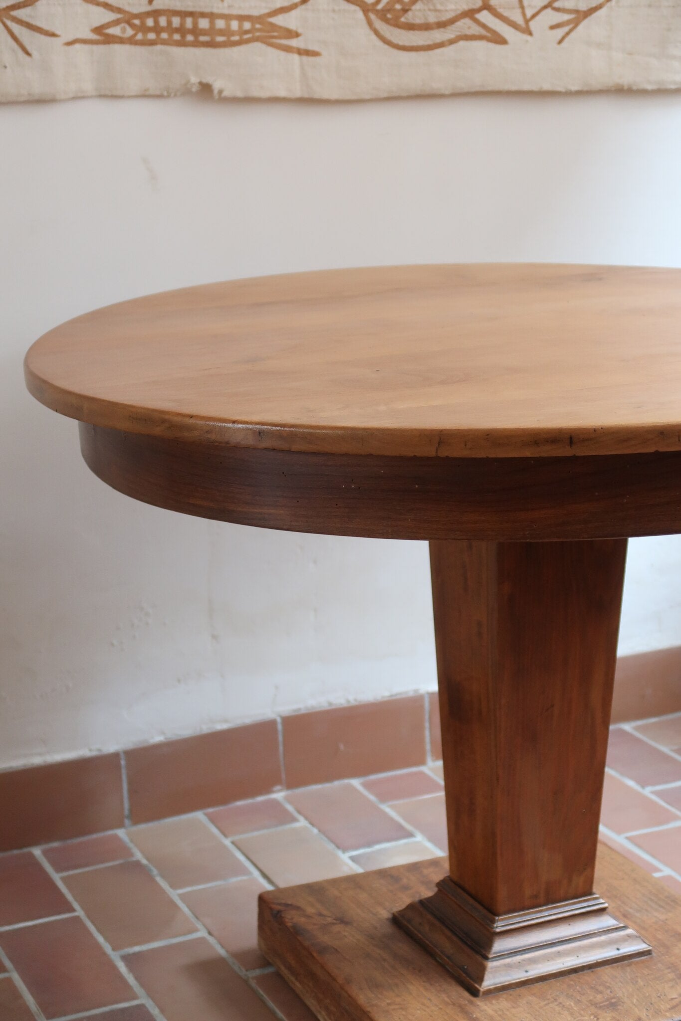 Table ronde vintage en frêne art déco, plateau circulaire à chant arrondi, pied central en colonne carrée sur socle mouluré à degrés, bois traité et rénové