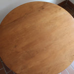 Table ronde vintage en frêne art déco, plateau circulaire à chant arrondi, pied central en colonne carrée sur socle mouluré à degrés, bois traité et rénové