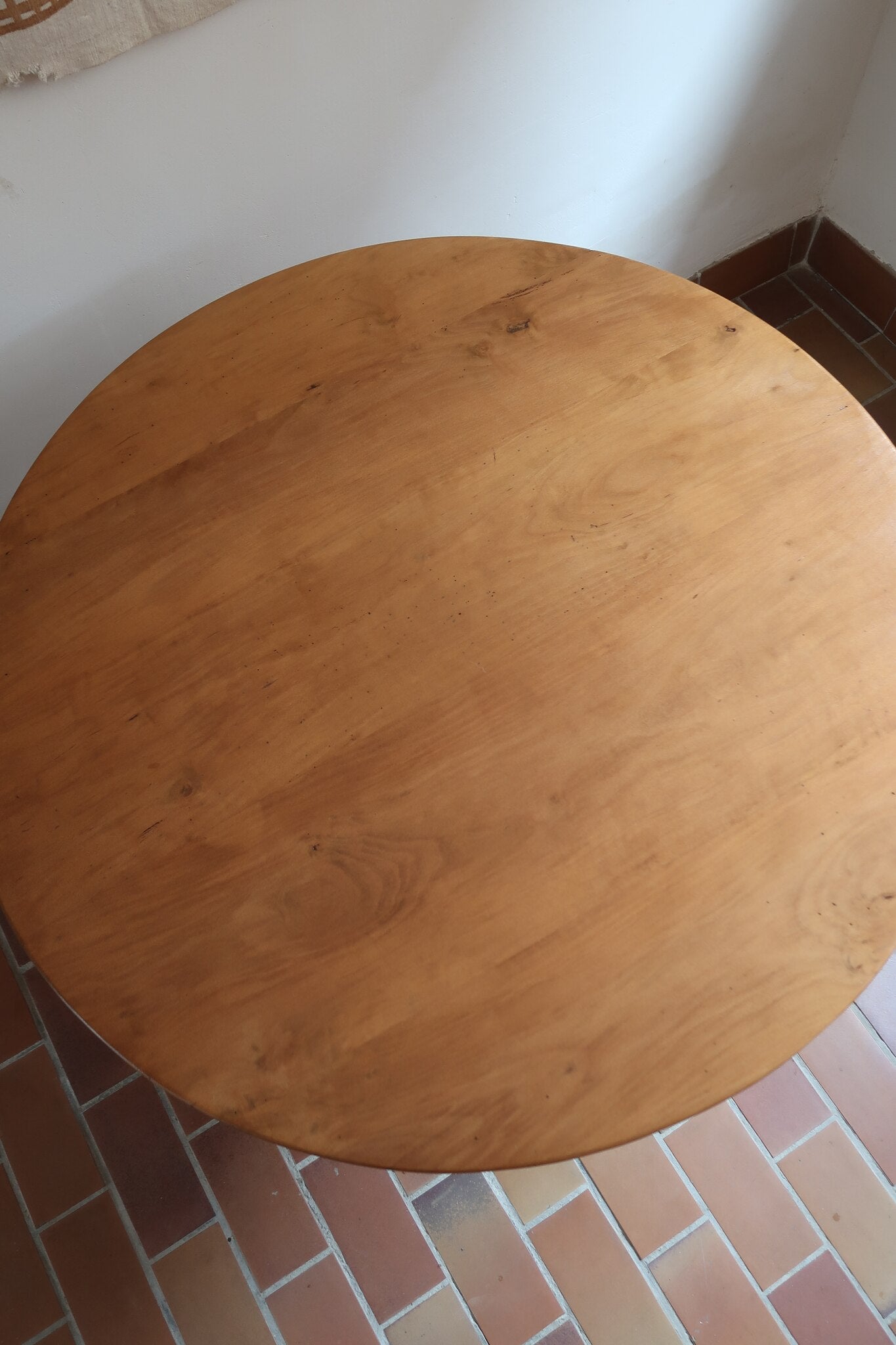 Table ronde vintage en frêne art déco, plateau circulaire à chant arrondi, pied central en colonne carrée sur socle mouluré à degrés, bois traité et rénové