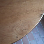 Table ronde vintage en frêne art déco, plateau circulaire à chant arrondi, pied central en colonne carrée sur socle mouluré à degrés, bois traité et rénové