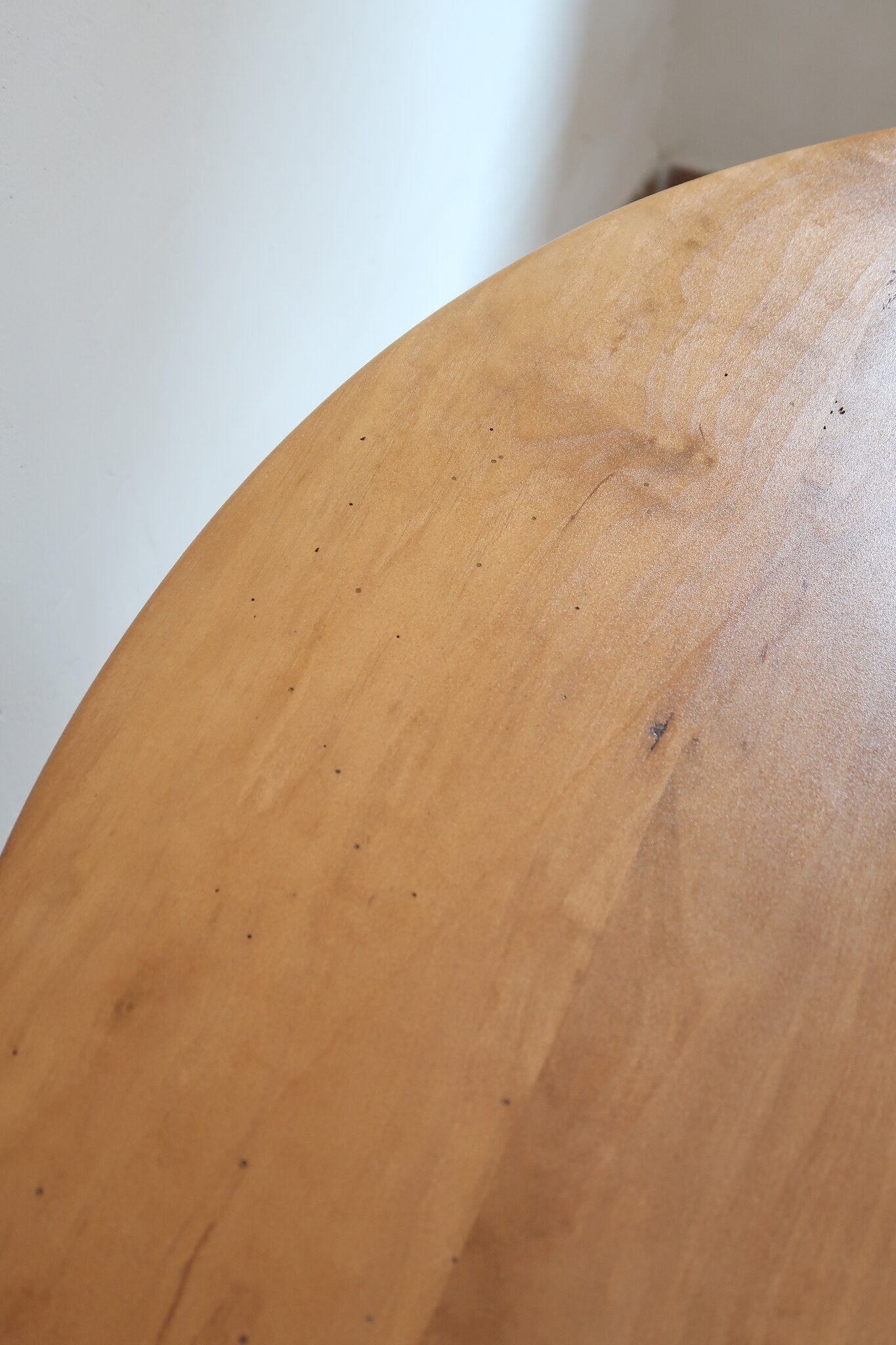 Table ronde vintage en frêne art déco, plateau circulaire à chant arrondi, pied central en colonne carrée sur socle mouluré à degrés, bois traité et rénové