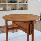 Table ronde extensible vintage en bois de hêtre massif, années 80, formée de deux demi-lunes assemblées par des taquets de bois pivotants, deux rallonges centrales, passant de 121 à 181 cm, démontable