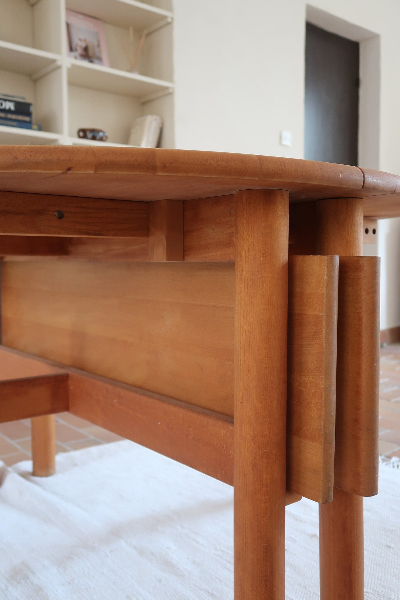Table ronde extensible vintage en bois de hêtre massif, années 80, formée de deux demi-lunes assemblées par des taquets de bois pivotants, deux rallonges centrales, passant de 121 à 181 cm, démontable