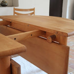 Table ronde extensible vintage en bois de hêtre massif, années 80, formée de deux demi-lunes assemblées par des taquets de bois pivotants, deux rallonges centrales, passant de 121 à 181 cm, démontable