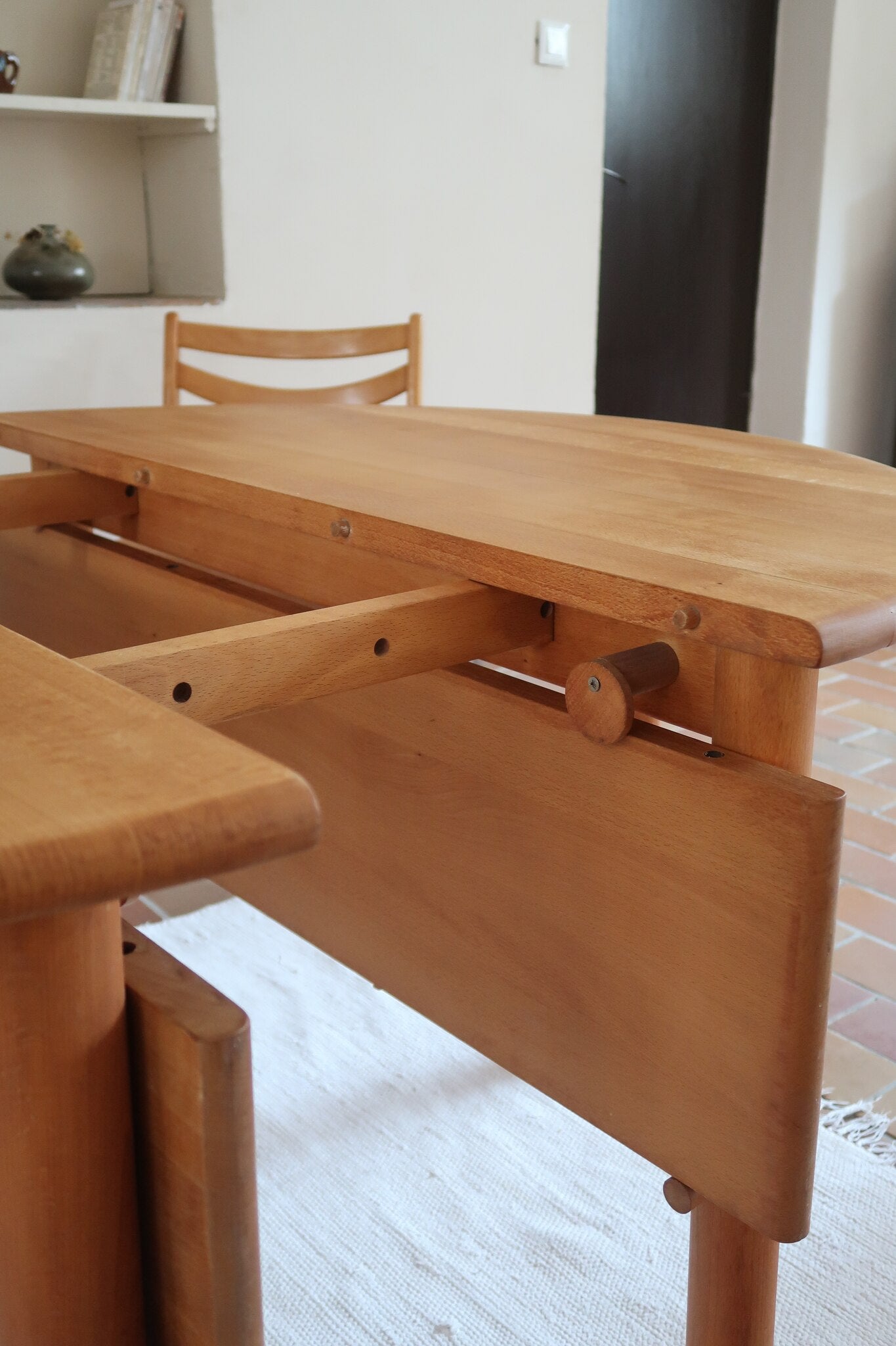 Table ronde extensible vintage en bois de hêtre massif, années 80, formée de deux demi-lunes assemblées par des taquets de bois pivotants, deux rallonges centrales, passant de 121 à 181 cm, démontable