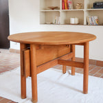 Table ronde extensible vintage en bois de hêtre massif, années 80, formée de deux demi-lunes assemblées par des taquets de bois pivotants, deux rallonges centrales, passant de 121 à 181 cm, démontable