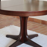 Table à manger ronde extensible vintage, pied central sculptural en étoile à quatre branches, bois foncé, rallonge centrale, design italien années 60