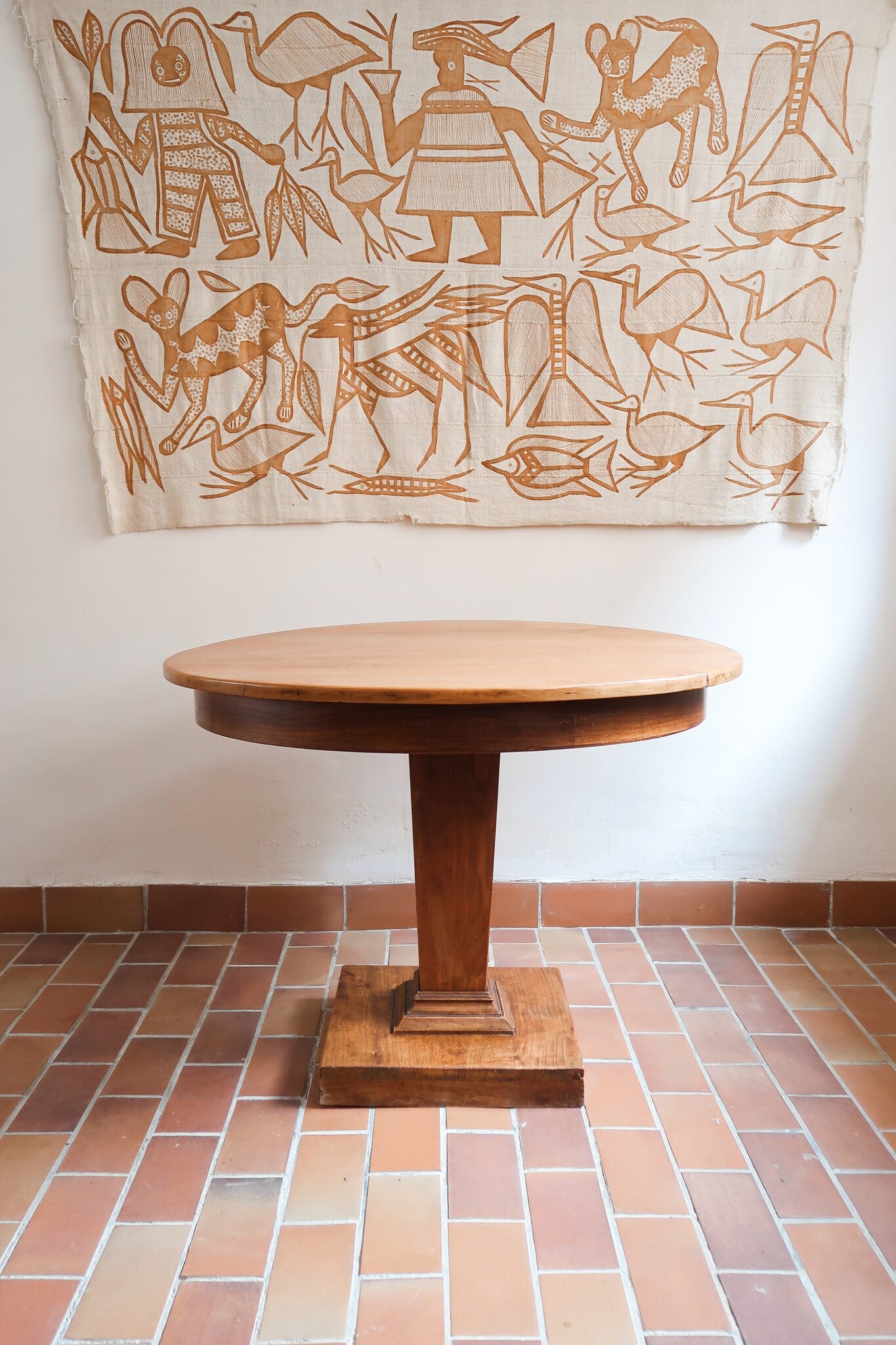 Table ronde vintage en frêne art déco, plateau circulaire à chant arrondi, pied central en colonne carrée sur socle mouluré à degrés, bois traité et rénové