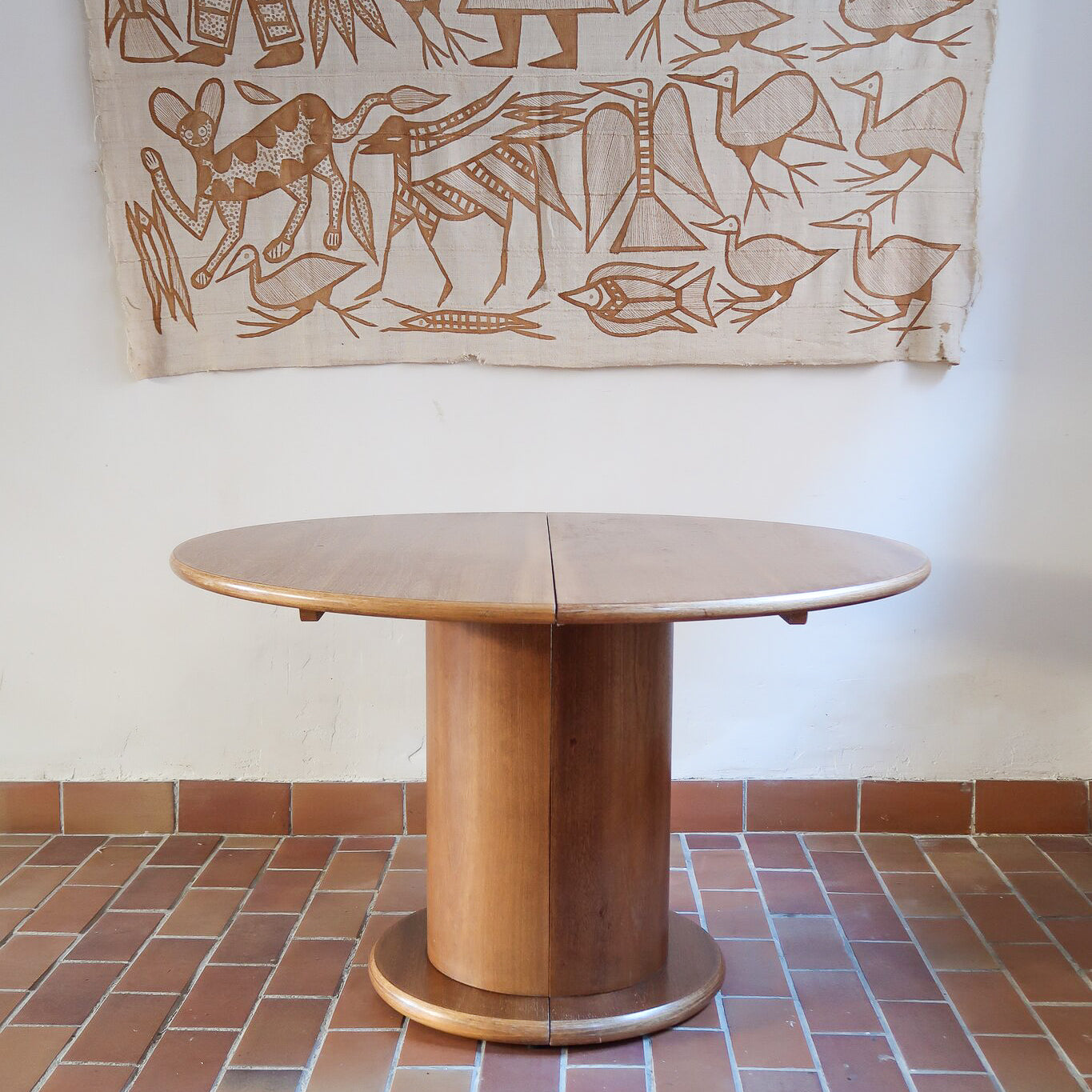 Table ronde vintage en bois blond, années 90, plateau de 118 cm posé sur un gros fût cylindrique plein cerclé d'une base ronde en retrait, esprit Art déco