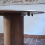 Table ronde vintage en bois blond, années 90, plateau de 118 cm posé sur un gros fût cylindrique plein cerclé d'une base ronde en retrait, esprit Art déco