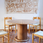 Table ronde vintage en bois blond, années 90, plateau de 118 cm posé sur un gros fût cylindrique plein cerclé d'une base ronde en retrait, esprit Art déco