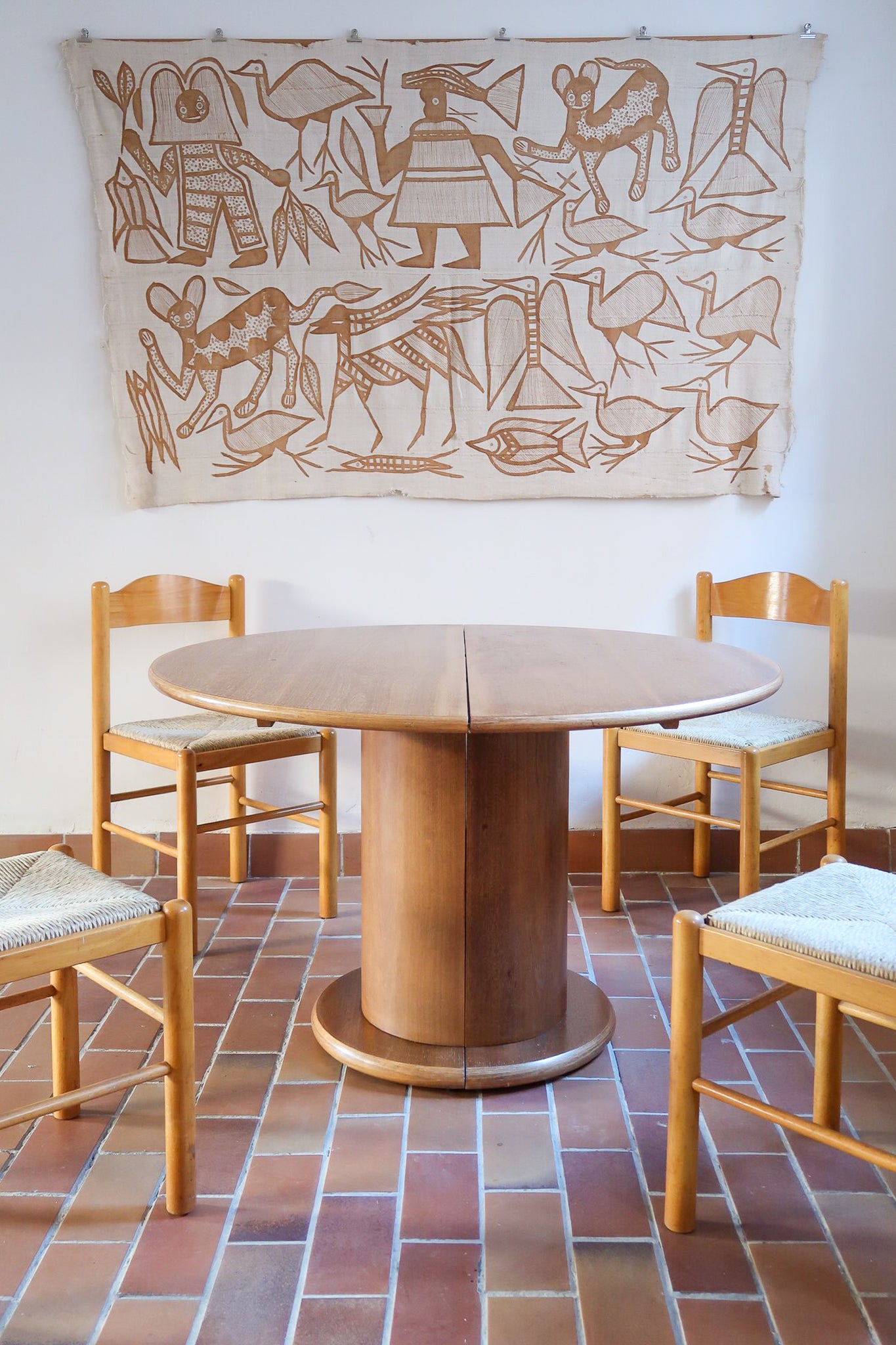 Table ronde vintage en bois blond, années 90, plateau de 118 cm posé sur un gros fût cylindrique plein cerclé d'une base ronde en retrait, esprit Art déco