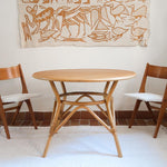 Table ronde vintage en rotin et bois clair, années 70, piètement tressé avec ligatures, plateau en bois patiné.