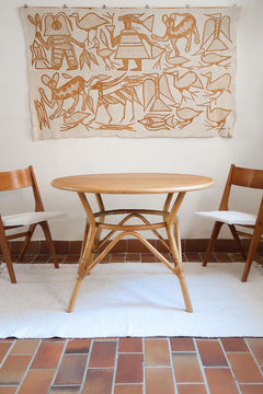 Table ronde vintage en rotin et bois clair, années 70, piètement tressé avec ligatures, plateau en bois patiné.