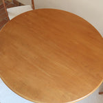 Table ronde vintage en rotin et bois clair, années 70, piètement tressé avec ligatures, plateau en bois patiné.