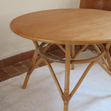 Table ronde vintage en rotin et bois clair, années 70, piètement tressé avec ligatures, plateau en bois patiné.