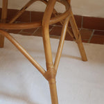 Table ronde vintage en rotin et bois clair, années 70, piètement tressé avec ligatures, plateau en bois patiné.