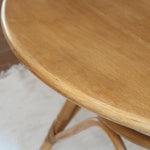 Table ronde vintage en rotin et bois clair, années 70, piètement tressé avec ligatures, plateau en bois patiné.