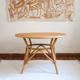 Table ronde vintage en rotin et bois clair, années 70, piètement tressé avec ligatures, plateau en bois patiné.