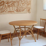 Table ronde vintage en rotin et bois clair, années 70, piètement tressé avec ligatures, plateau en bois patiné.