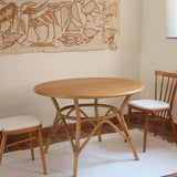 Table ronde vintage en rotin et bois clair, années 70, piètement tressé avec ligatures, plateau en bois patiné.