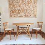 Table ronde vintage en rotin et bois clair, années 70, piètement tressé avec ligatures, plateau en bois patiné.