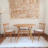 Table ronde vintage en rotin et bois clair, années 70, piètement tressé avec ligatures, plateau en bois patiné.