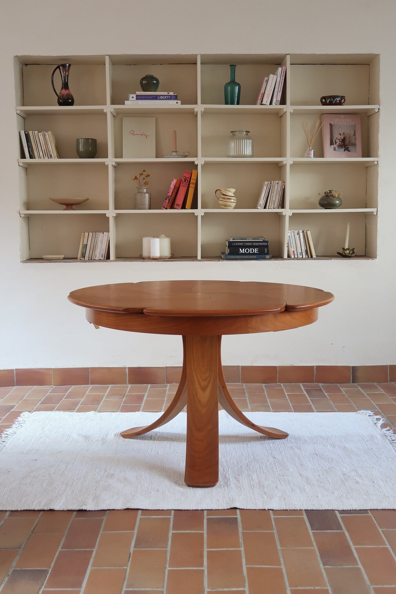Table ronde vintage en orme massif années 80, prototype jamais produit, plateau fixe composé de six segments dessinés en pétales autour du centre, piétement central à quatre jambes larges cintrées