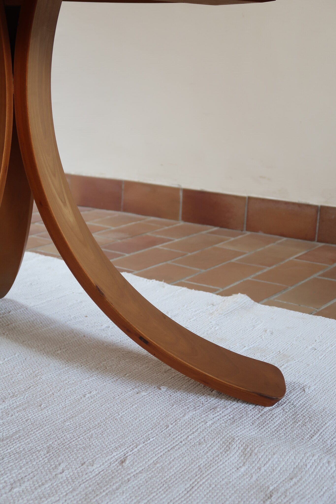 Table ronde vintage en orme massif années 80, prototype jamais produit, plateau fixe composé de six segments dessinés en pétales autour du centre, piétement central à quatre jambes larges cintrées