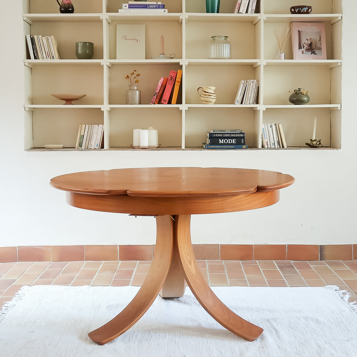 Table ronde vintage en orme massif années 80, prototype jamais produit, plateau fixe composé de six segments dessinés en pétales autour du centre, piétement central à quatre jambes larges cintrées