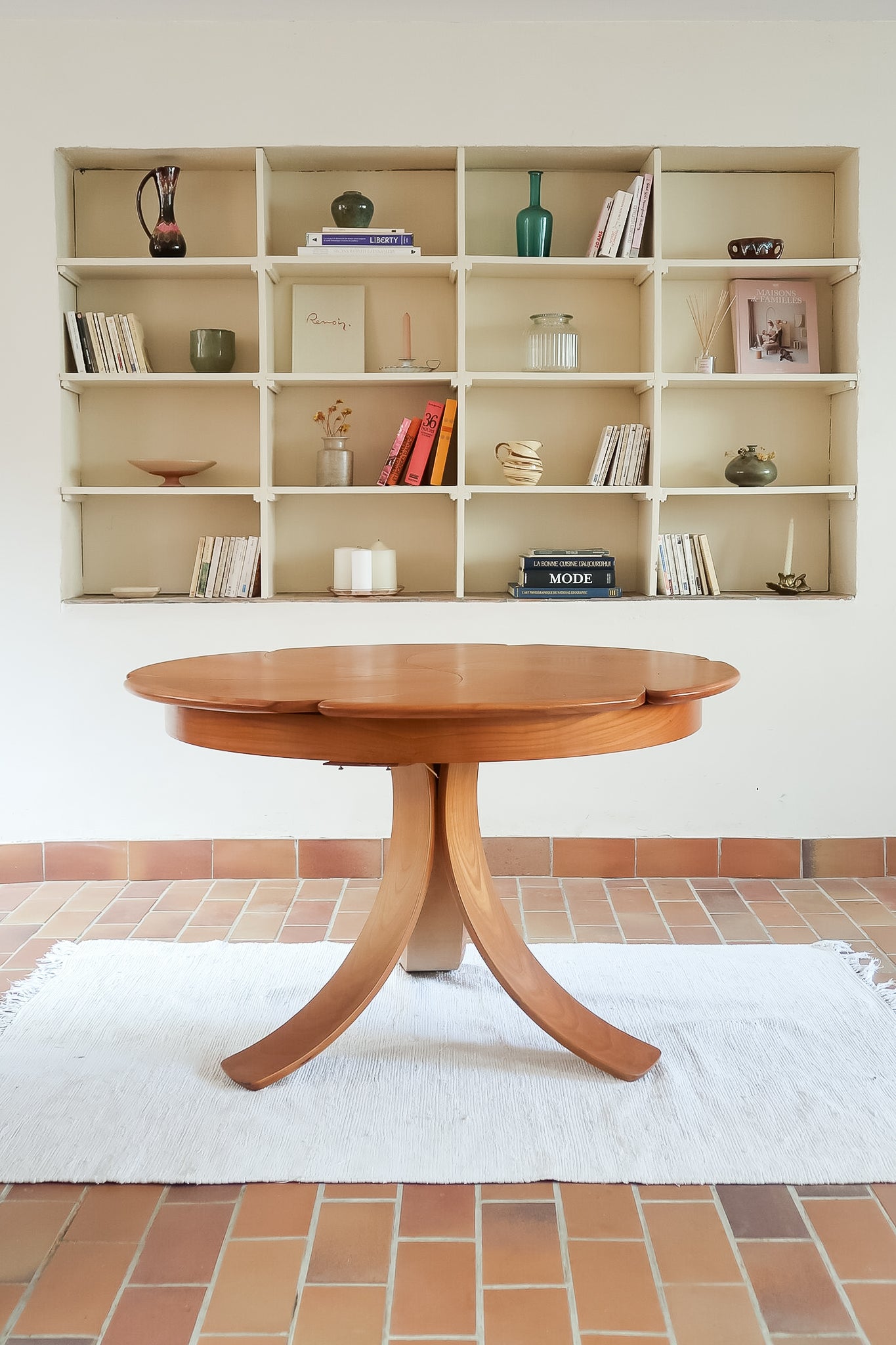 Table ronde vintage en orme massif années 80, prototype jamais produit, plateau fixe composé de six segments dessinés en pétales autour du centre, piétement central à quatre jambes larges cintrées