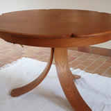 Table ronde vintage en orme massif années 80, prototype jamais produit, plateau fixe composé de six segments dessinés en pétales autour du centre, piétement central à quatre jambes larges cintrées