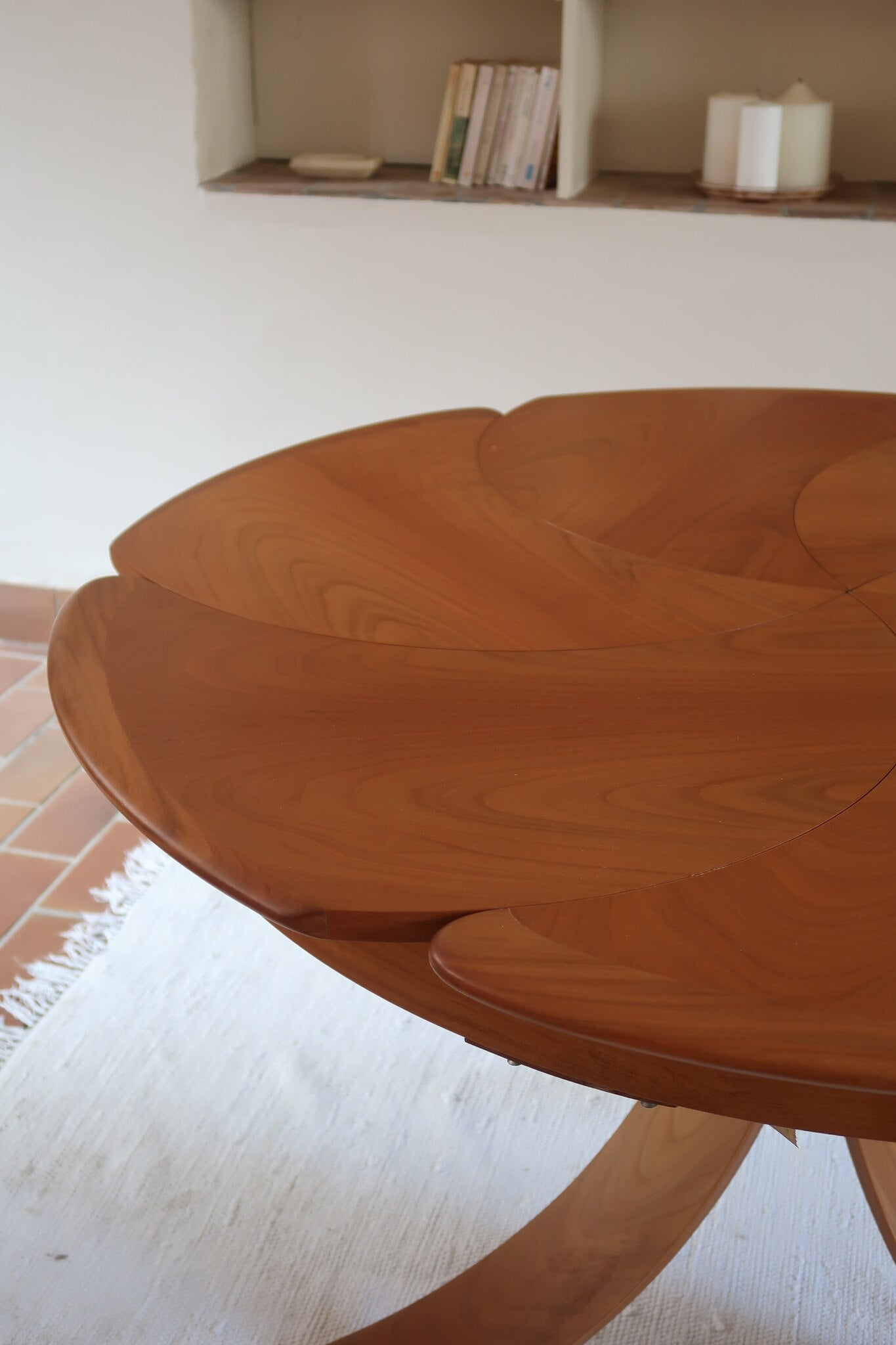 Table ronde vintage en orme massif années 80, prototype jamais produit, plateau fixe composé de six segments dessinés en pétales autour du centre, piétement central à quatre jambes larges cintrées