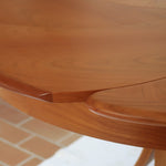 Table ronde vintage en orme massif années 80, prototype jamais produit, plateau fixe composé de six segments dessinés en pétales autour du centre, piétement central à quatre jambes larges cintrées