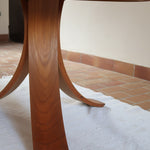 Table ronde vintage en orme massif années 80, prototype jamais produit, plateau fixe composé de six segments dessinés en pétales autour du centre, piétement central à quatre jambes larges cintrées