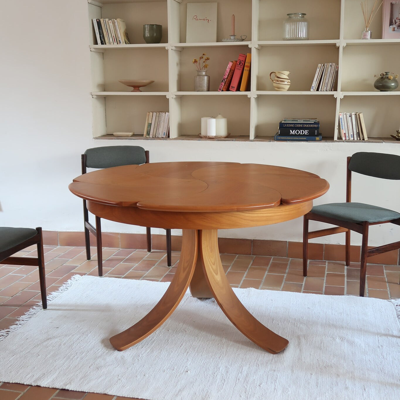 Table ronde vintage en orme massif années 80, prototype jamais produit, plateau fixe composé de six segments dessinés en pétales autour du centre, piétement central à quatre jambes larges cintrées