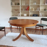 Table ronde vintage en orme massif années 80, prototype jamais produit, plateau fixe composé de six segments dessinés en pétales autour du centre, piétement central à quatre jambes larges cintrées