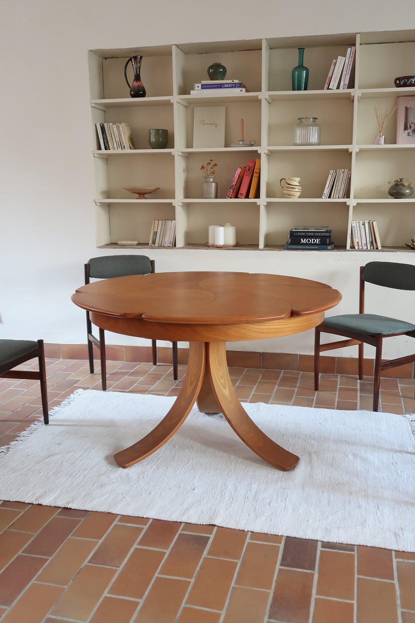 Table ronde vintage en orme massif années 80, prototype jamais produit, plateau fixe composé de six segments dessinés en pétales autour du centre, piétement central à quatre jambes larges cintrées