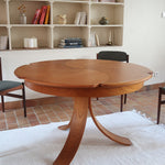 Table ronde vintage en orme massif années 80, prototype jamais produit, plateau fixe composé de six segments dessinés en pétales autour du centre, piétement central à quatre jambes larges cintrées