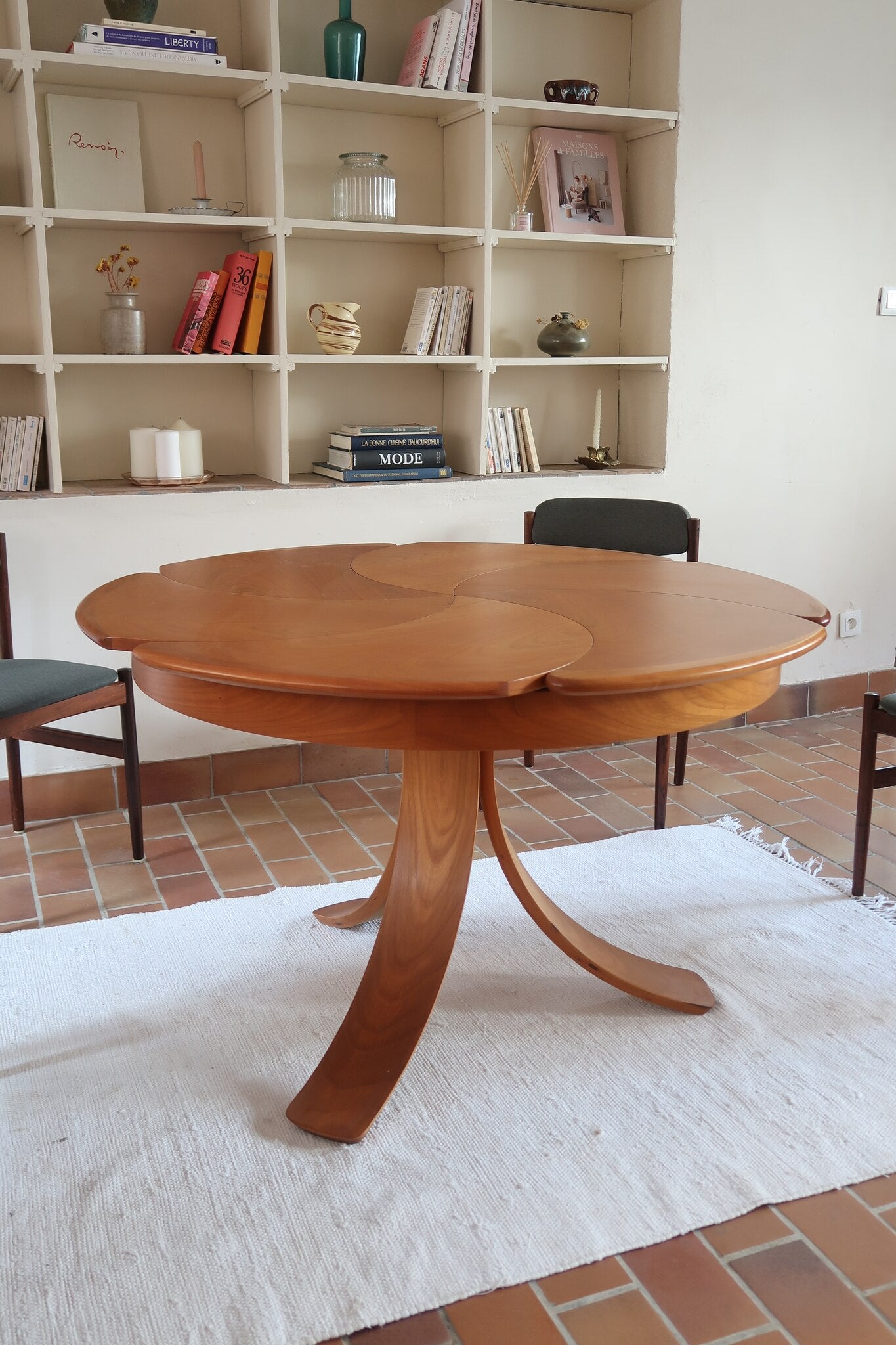 Table ronde vintage en orme massif années 80, prototype jamais produit, plateau fixe composé de six segments dessinés en pétales autour du centre, piétement central à quatre jambes larges cintrées
