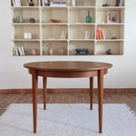 Table à manger ronde extensible vintage en teck miel, pieds fuseau, deux rallonges jusqu'à douze couverts, style scandinave fabrication française années 60