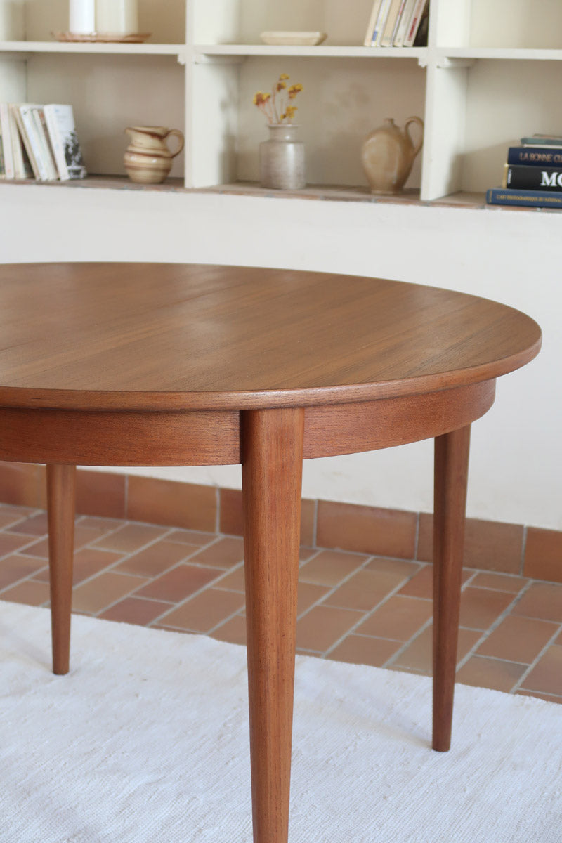 Table à manger ronde extensible vintage en teck miel, pieds fuseau, deux rallonges jusqu'à douze couverts, style scandinave fabrication française années 60
