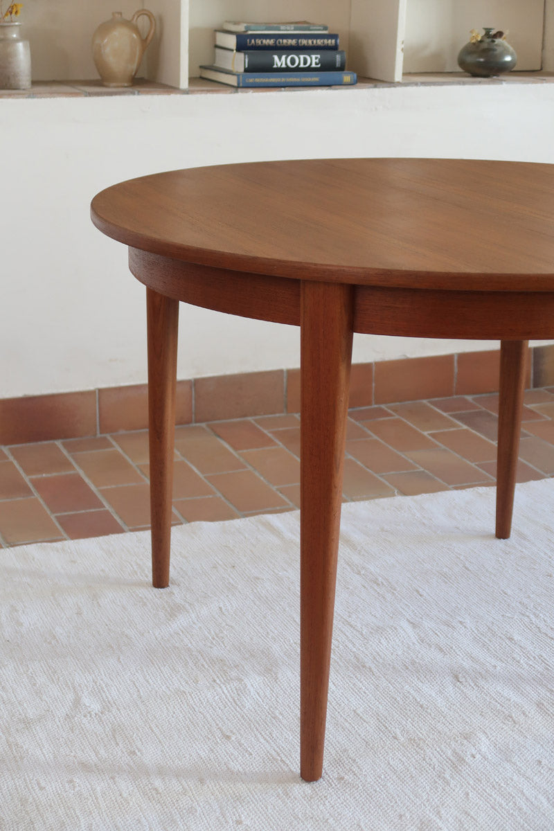 Table à manger ronde extensible vintage en teck miel, pieds fuseau, deux rallonges jusqu'à douze couverts, style scandinave fabrication française années 60
