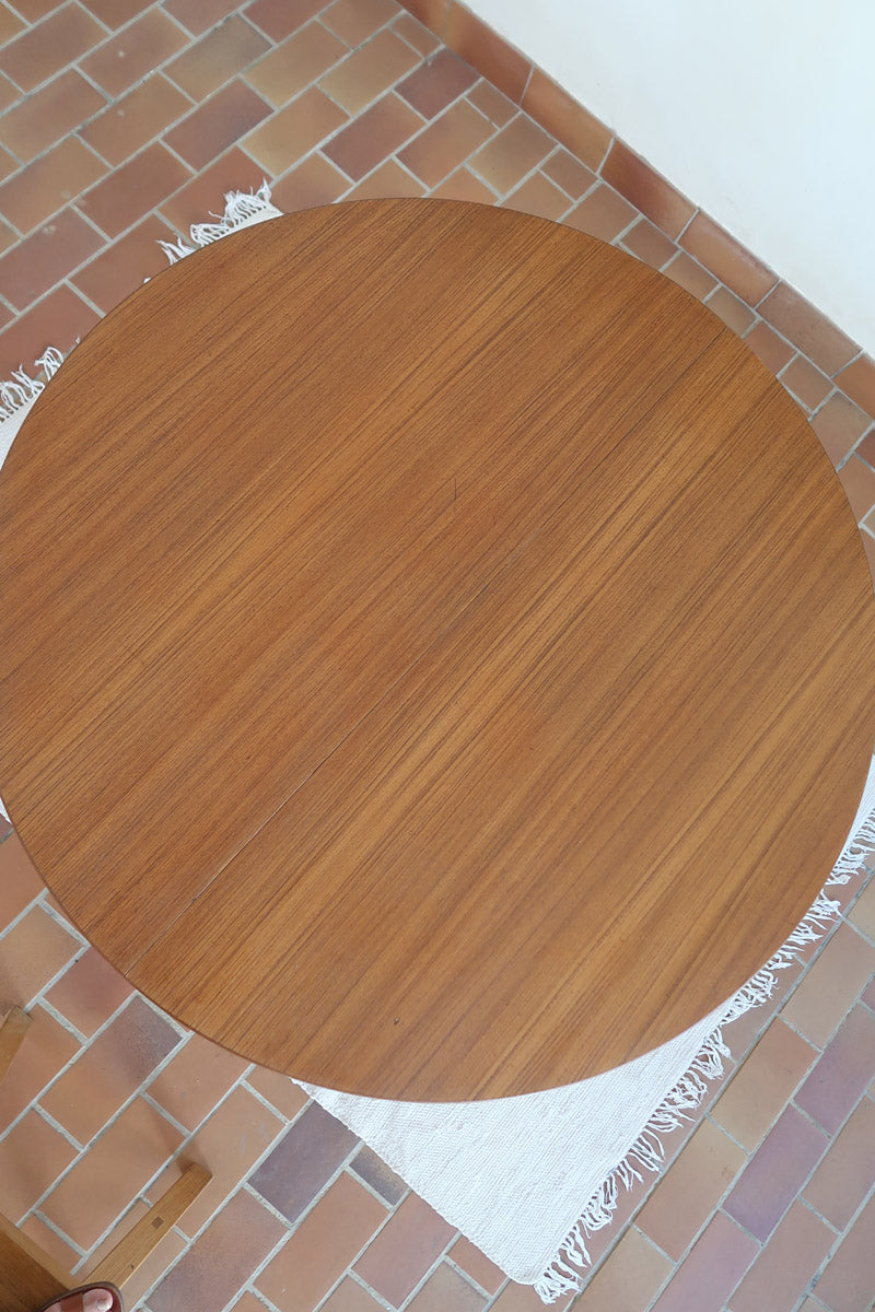 Table à manger ronde extensible vintage en teck miel, pieds fuseau, deux rallonges jusqu'à douze couverts, style scandinave fabrication française années 60