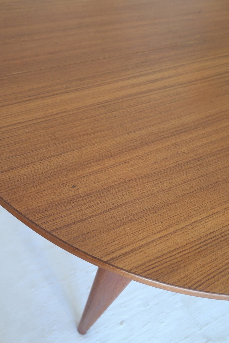 Table à manger ronde extensible vintage en teck miel, pieds fuseau, deux rallonges jusqu'à douze couverts, style scandinave fabrication française années 60